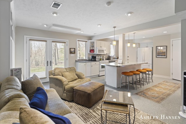 5615 Egypt Valley Ave NE, Belmont, MI 49306 - living room featuring french doors, baseboards, and a textured ceiling