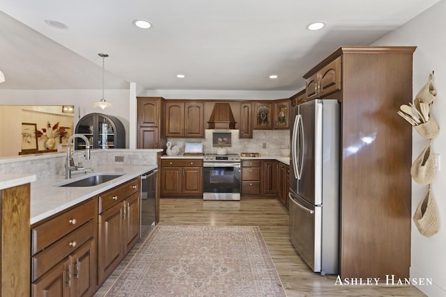 5615 Egypt Valley Ave NE, Belmont, MI 49306 - kitchen featuring stainless steel appliances, a sink, light wood-style floors, custom exhaust hood, and light countertops