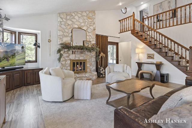 5615 Egypt Valley Ave NE, Belmont, MI 49306 - living room with plenty of natural light, light wood-style floors, a stone fireplace, stairs, and high vaulted ceiling