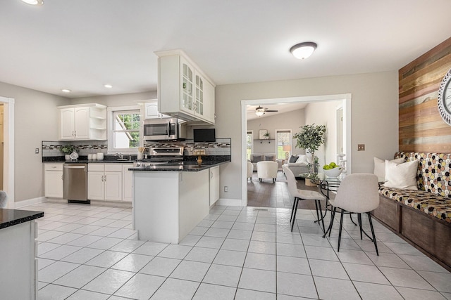 6010 Long Lake Rd, Berrien Springs, MI 49103 - kitchen with a peninsula, light tile patterned floors, tasteful backsplash, and stainless steel appliances