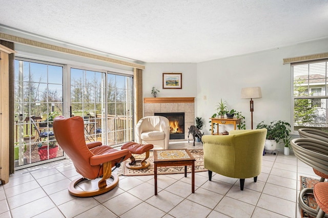 living room with healthy amount of natural light, light tile patterned flooring, a fireplace, and a textured ceiling