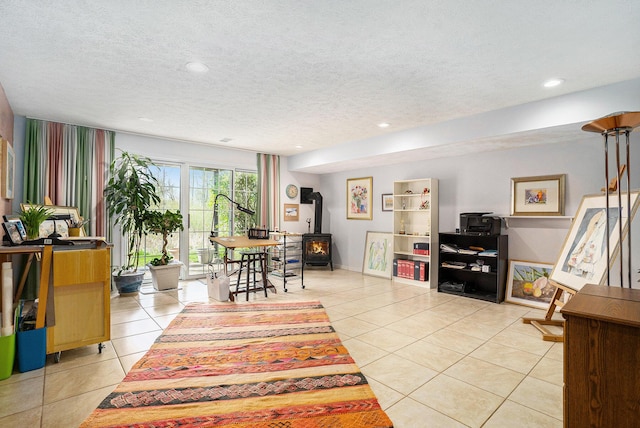 living room with a wood stove, light tile patterned floors, a textured ceiling, and recessed lighting