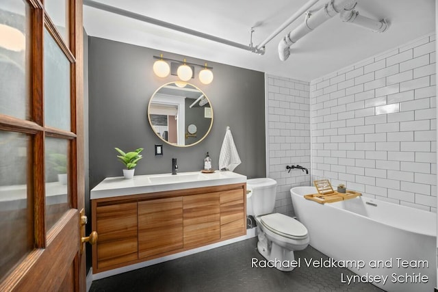 full bath featuring vanity, toilet, and a soaking tub