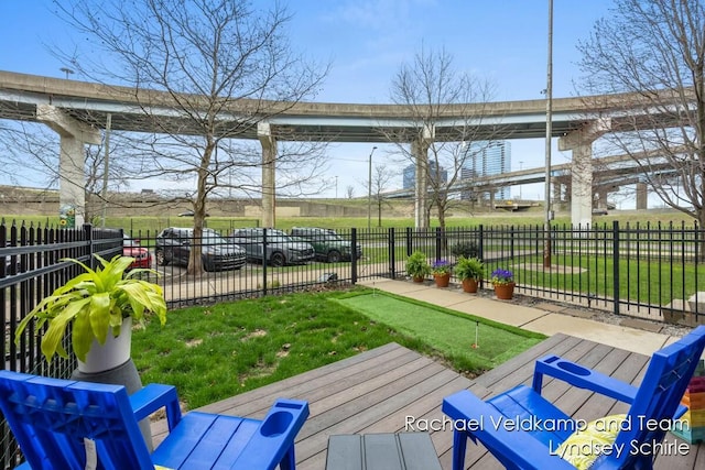wooden terrace with a yard and fence