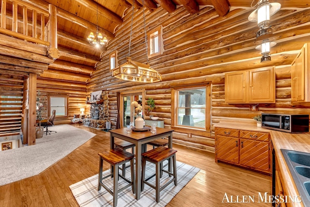 dining area featuring high vaulted ceiling, an inviting chandelier, light wood-type flooring, wooden ceiling, and beam ceiling