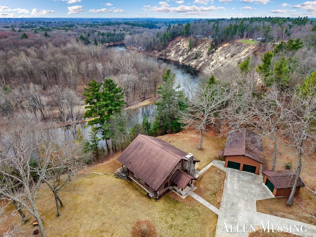 aerial view featuring a wooded view and a water view