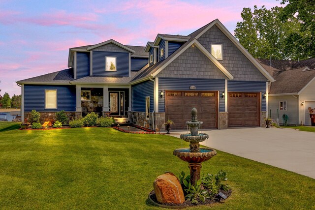 7140 Holiday Dr, Canadian Lakes, MI 49346 - view of front facade with concrete driveway, a yard, stone siding, and a shingled roof
