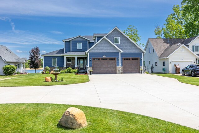 7140 Holiday Dr, Canadian Lakes, MI 49346 - craftsman inspired home featuring driveway, stone siding, and a front lawn