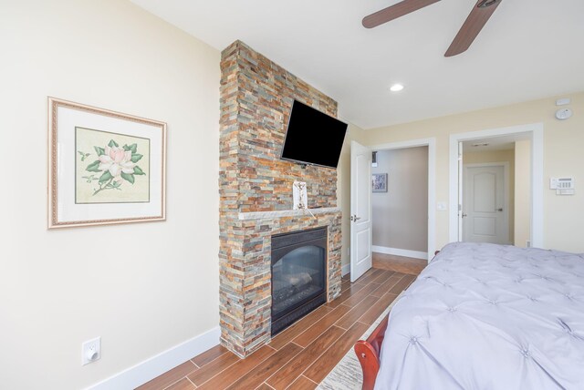 7140 Holiday Dr, Canadian Lakes, MI 49346 - bedroom with ceiling fan, a fireplace, recessed lighting, wood tiled floor, and baseboards