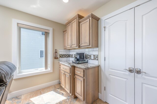 7140 Holiday Dr, Canadian Lakes, MI 49346 - kitchen with decorative backsplash, light stone counters, and baseboards