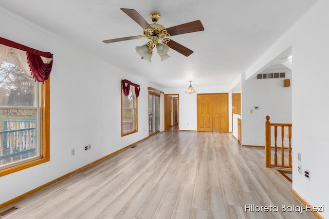 unfurnished living room with light wood finished floors, visible vents, and a ceiling fan