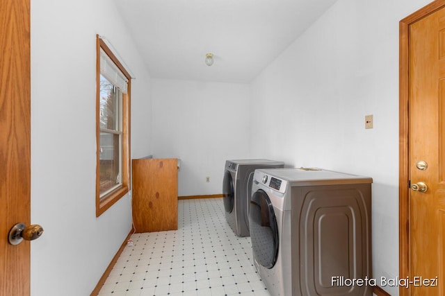 laundry area featuring baseboards, light floors, washer and dryer, and laundry area