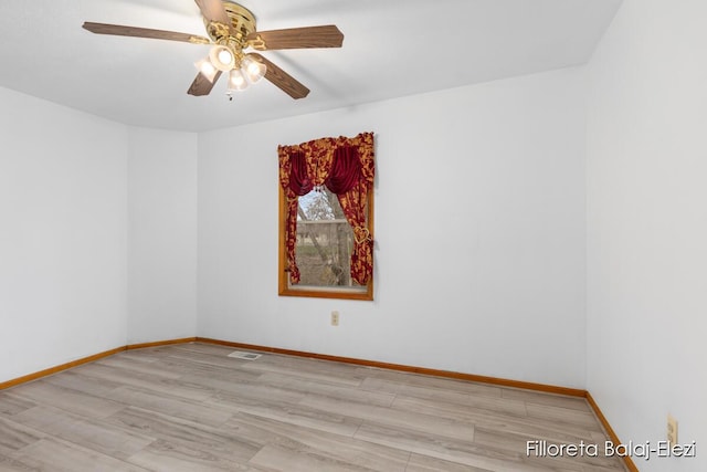 unfurnished room featuring visible vents, baseboards, ceiling fan, and wood finished floors