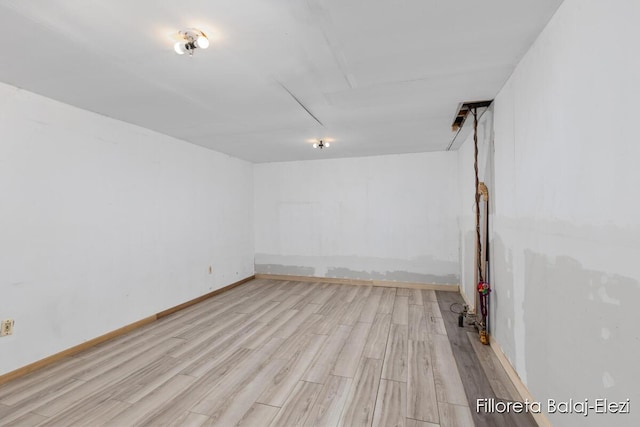 empty room with baseboards and wood finished floors
