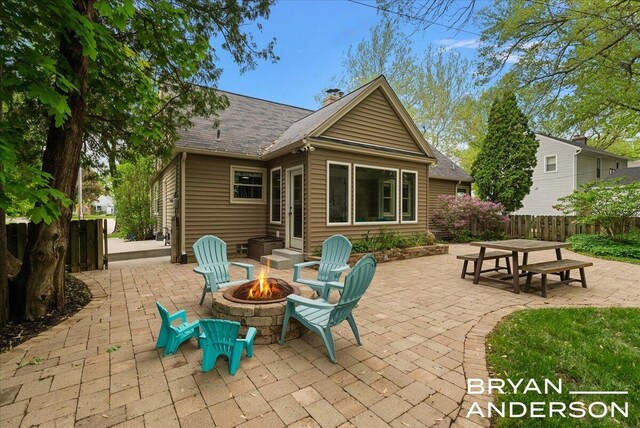 2120 Englewood Dr SE, East Grand Rapids, MI 49506 - rear view of property featuring an outdoor fire pit, a patio area, a chimney, and roof with shingles