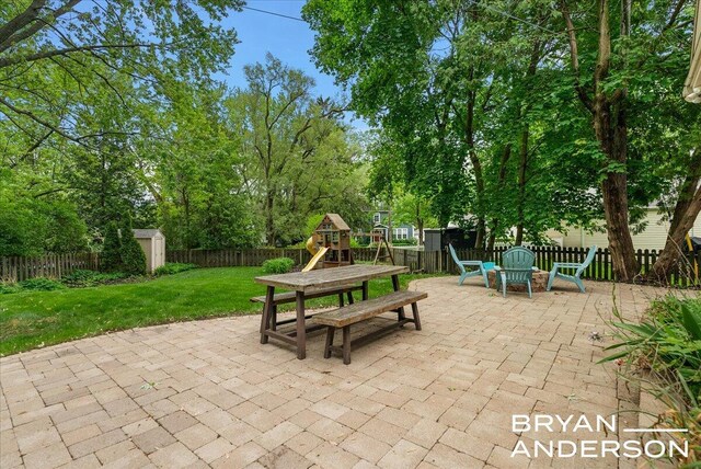 2120 Englewood Dr SE, East Grand Rapids, MI 49506 - view of patio featuring a playground and view of wooded area