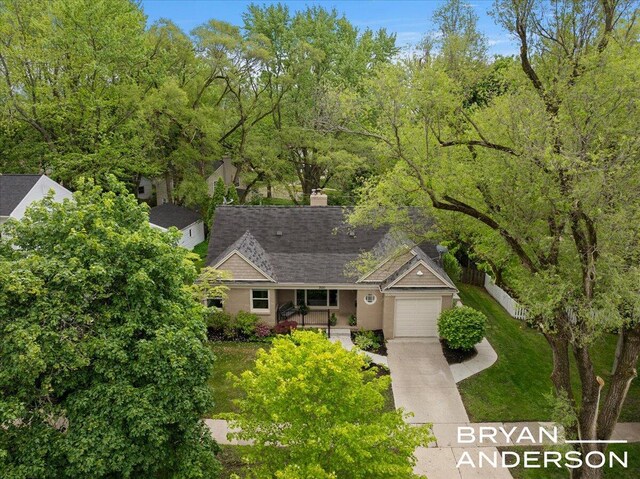2120 Englewood Dr SE, East Grand Rapids, MI 49506 - view of front facade with concrete driveway, a garage, a shingled roof, a porch, and a chimney