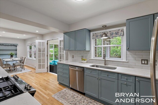2120 Englewood Dr SE, East Grand Rapids, MI 49506 - kitchen with dishwasher, a sink, light wood-style floors, backsplash, and gray cabinets