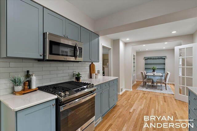 2120 Englewood Dr SE, East Grand Rapids, MI 49506 - kitchen featuring stainless steel appliances, light wood-type flooring, tasteful backsplash, baseboards, and recessed lighting