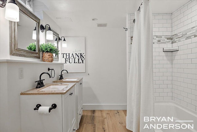 2120 Englewood Dr SE, East Grand Rapids, MI 49506 - full bathroom with wood finished floors, double vanity, shower / tub combo, and baseboards