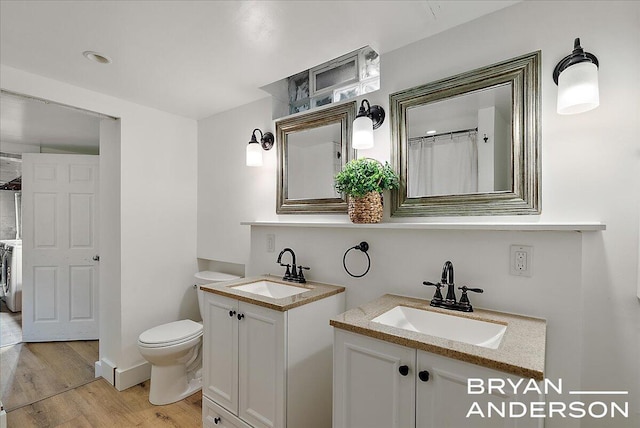 2120 Englewood Dr SE, East Grand Rapids, MI 49506 - bathroom featuring wood finished floors, two vanities, and toilet