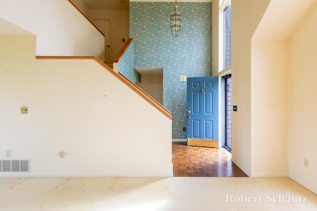 stairs featuring baseboards, wallpapered walls, and visible vents
