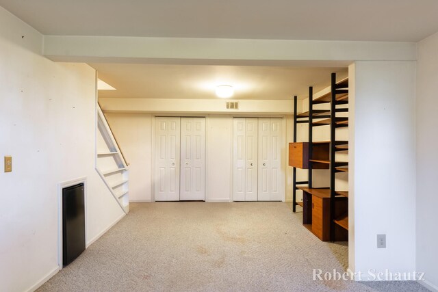 interior space with baseboards, visible vents, and carpet