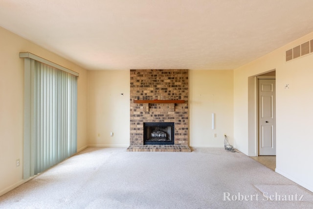 unfurnished living room with carpet flooring, baseboards, visible vents, and a brick fireplace