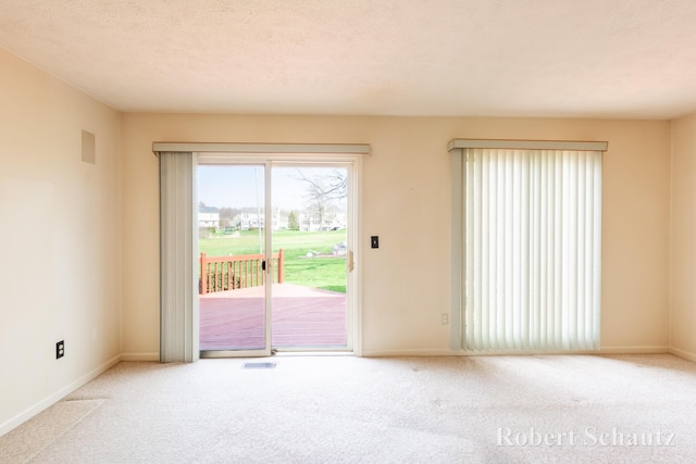 carpeted empty room featuring baseboards and visible vents