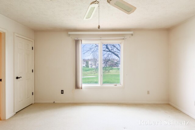 spare room with carpet floors, baseboards, and a textured ceiling