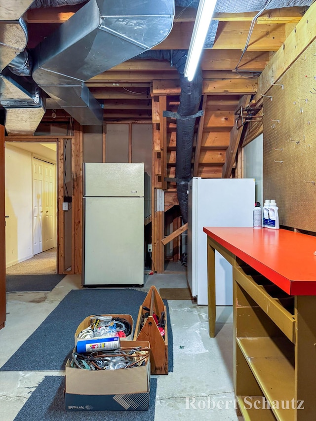 unfinished below grade area featuring freestanding refrigerator