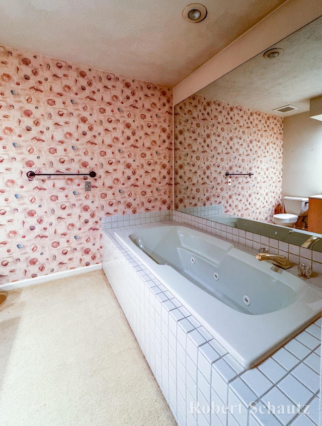 full bathroom featuring toilet, a tub with jets, a textured ceiling, and visible vents