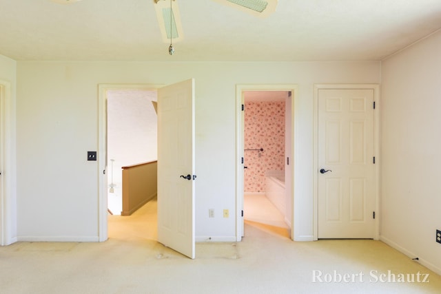 unfurnished bedroom with carpet floors, baseboards, ceiling fan, and connected bathroom