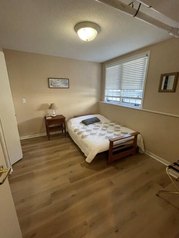 bedroom with baseboards and wood finished floors
