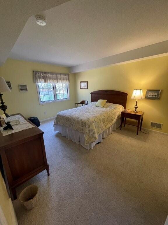 bedroom featuring visible vents, baseboards, and carpet