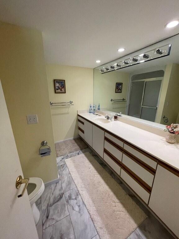bathroom with toilet, an enclosed shower, recessed lighting, vanity, and marble finish floor