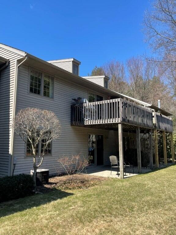 back of property with a yard, central AC unit, a deck, and a patio