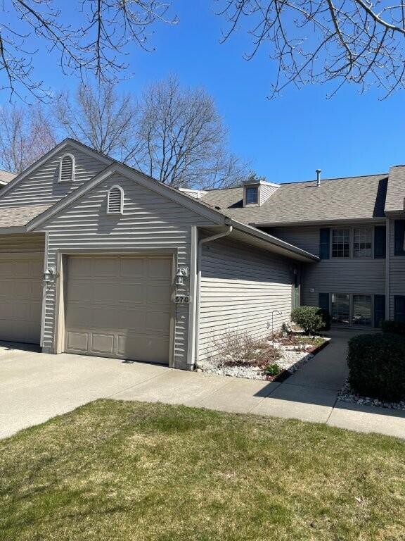 view of front facade featuring a shingled roof and a garage