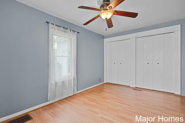 1864 92nd St SW, Byron Center, MI 49315 - unfurnished bedroom with wood finished floors, two closets, baseboards, and ceiling fan