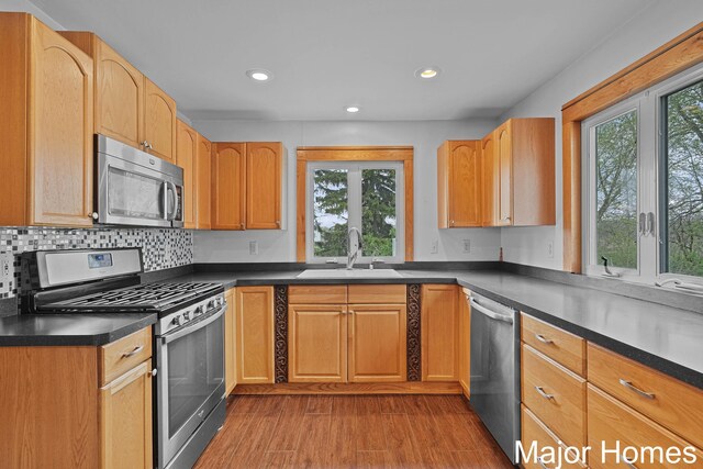 1864 92nd St SW, Byron Center, MI 49315 - kitchen featuring stainless steel appliances, a sink, dark countertops, recessed lighting, and wood finished floors