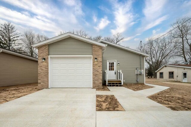 308 Hillview St, Buchanan, MI 49107 - view of front of house featuring concrete driveway, brick siding, and an attached garage