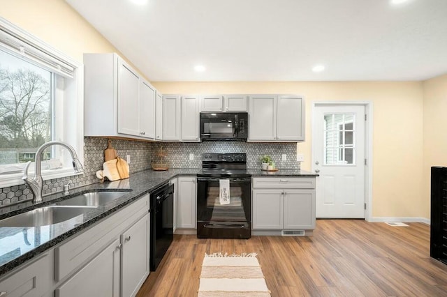 308 Hillview St, Buchanan, MI 49107 - kitchen featuring a sink, a wealth of natural light, black appliances, and light wood finished floors