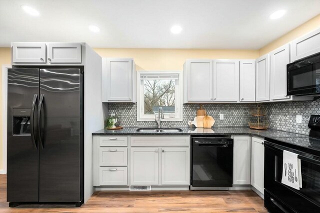 308 Hillview St, Buchanan, MI 49107 - kitchen with decorative backsplash, visible vents, a sink, and black appliances
