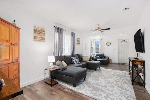 living area featuring wood finished floors, ceiling fan, baseboards, and visible vents