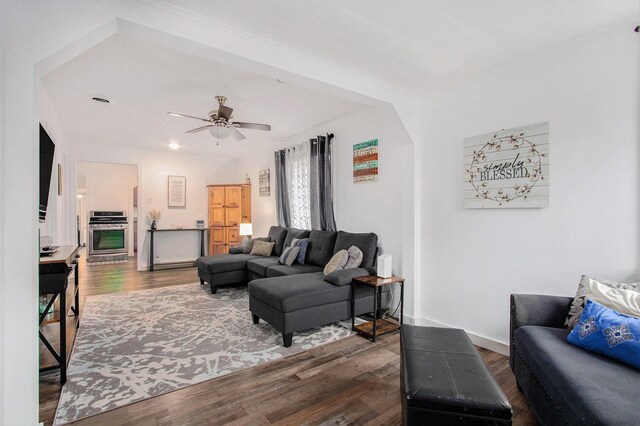 living area featuring ceiling fan, baseboards, and wood finished floors