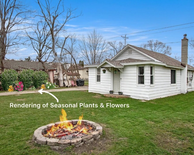 rear view of house featuring a yard, an outdoor fire pit, a chimney, and a shingled roof