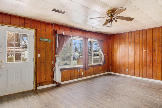 3309 Greenfield Ave, Kalamazoo, MI 49048 - unfurnished room with visible vents, baseboards, ceiling fan, wood finished floors, and wood walls