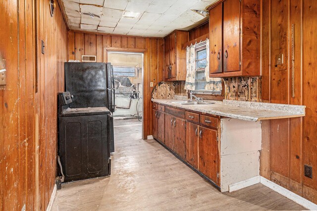 3309 Greenfield Ave, Kalamazoo, MI 49048 - kitchen with a sink, light countertops, freestanding refrigerator, brown cabinets, and range