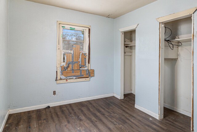 3309 Greenfield Ave, Kalamazoo, MI 49048 - unfurnished bedroom with dark wood-style floors, baseboards, and multiple closets