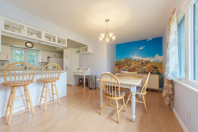 3010 Hill An Brook Dr, Portage, MI 49024 - dining area with light wood-type flooring, a chandelier, and baseboards